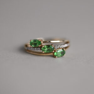 Contemporary 9ct gold tsavorite three stone crossover ring